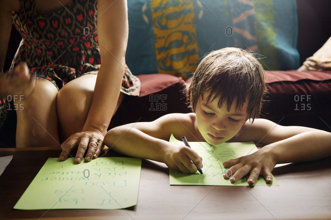 Boy with woman learning to write alphabet