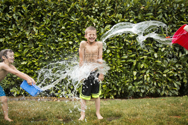 Young boy being splashed with water in summer