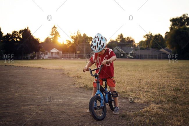 Boy on a bike in a suburban park at dusk