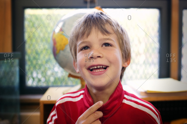 Portrait of young boy laughing in a classroom