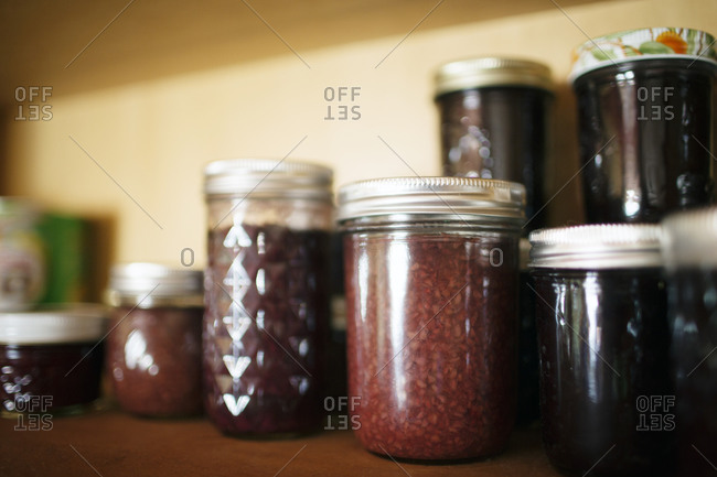 Various jars of preserves on kitchen shelf