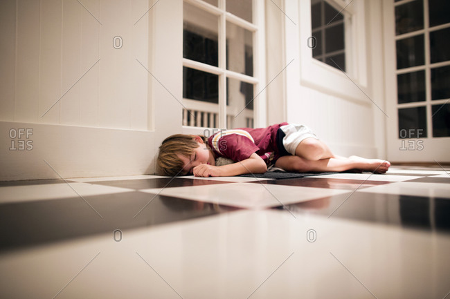 Little boy asleep on kitchen floor at night