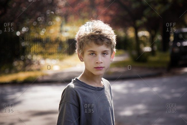 Portrait of boy by neighborhood street in summer