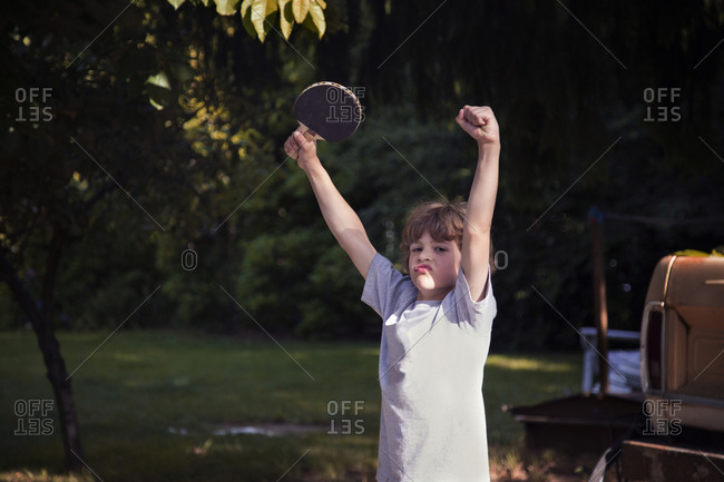 Young boy with ping pong paddle celebrating