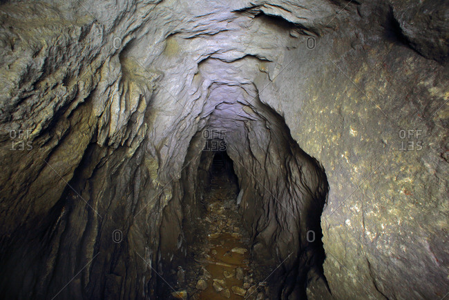 Tunnel in rock cave stock photo - OFFSET