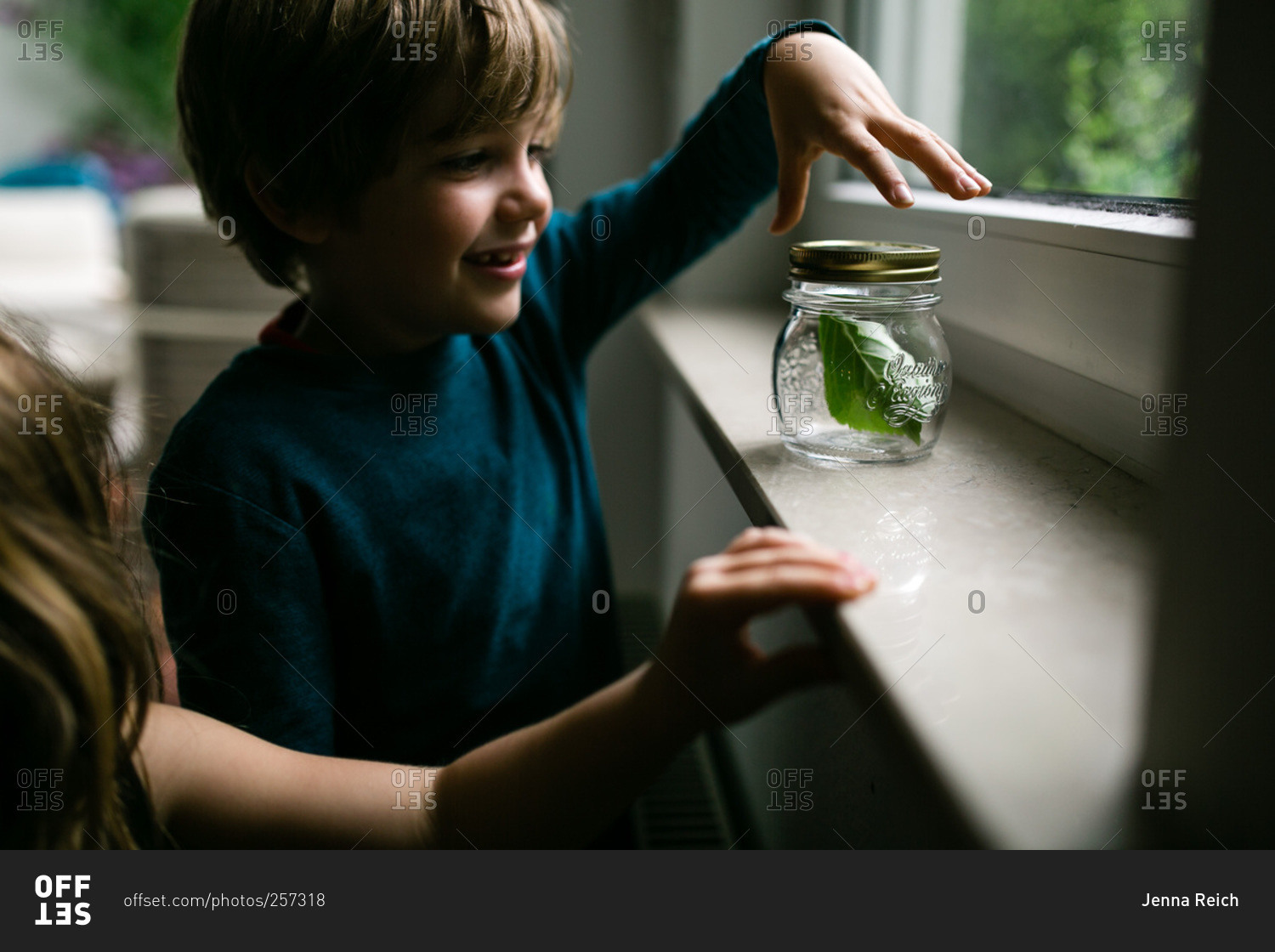 Boy with insect he collected in a jar