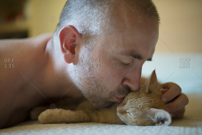 Man kissing kitten, close-up - Offset