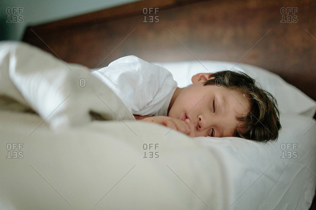 Young boy sleeping peacefully on bed