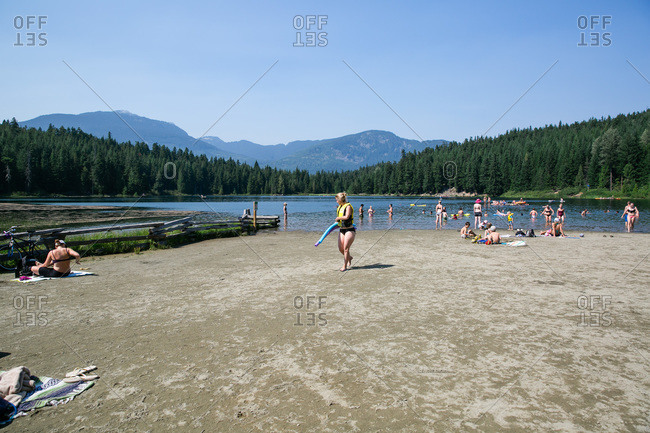 Whistler, BC, Canada - August 12, 2015: People on lake beach in wilderness setting