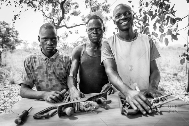 Paicho, Uganda - March 5, 2015: Three young men with woodworking tools