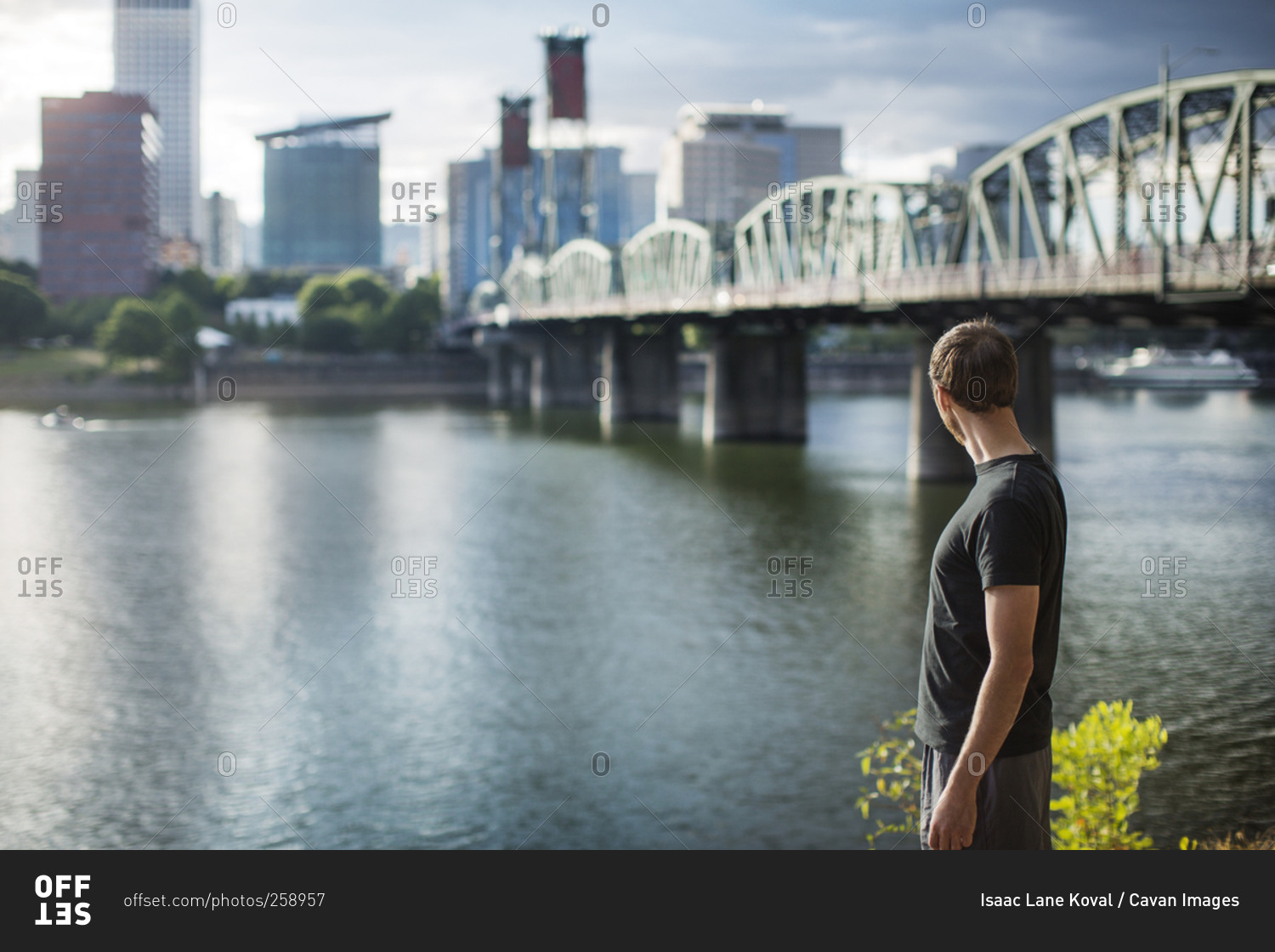 Man in workout clothes looking across city river