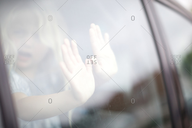 Kid touching window of car from inside vehicle