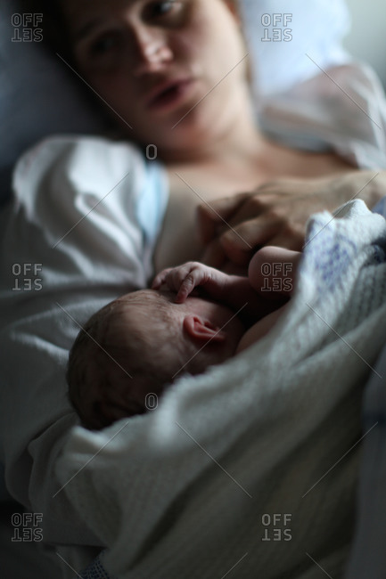 Newborn baby and mother in hospital bed