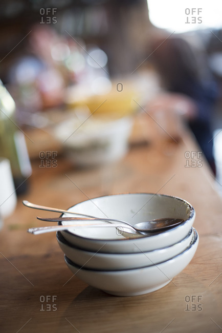 Stack of dirty bowls and spoons on a countertop