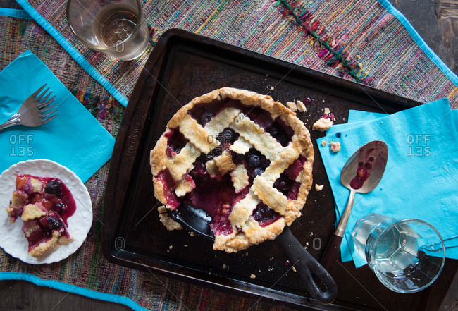 Blueberry and plum pie with a piece on a plate