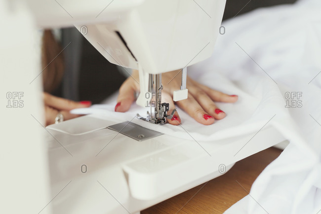 Hands of a woman using a sewing machine