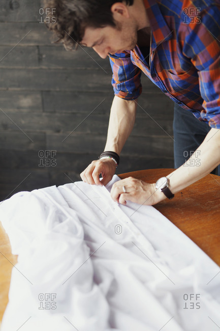 Man folding the edge of white cloth