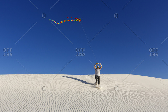 Flying a kite from dunes in White Sands, New Mexico