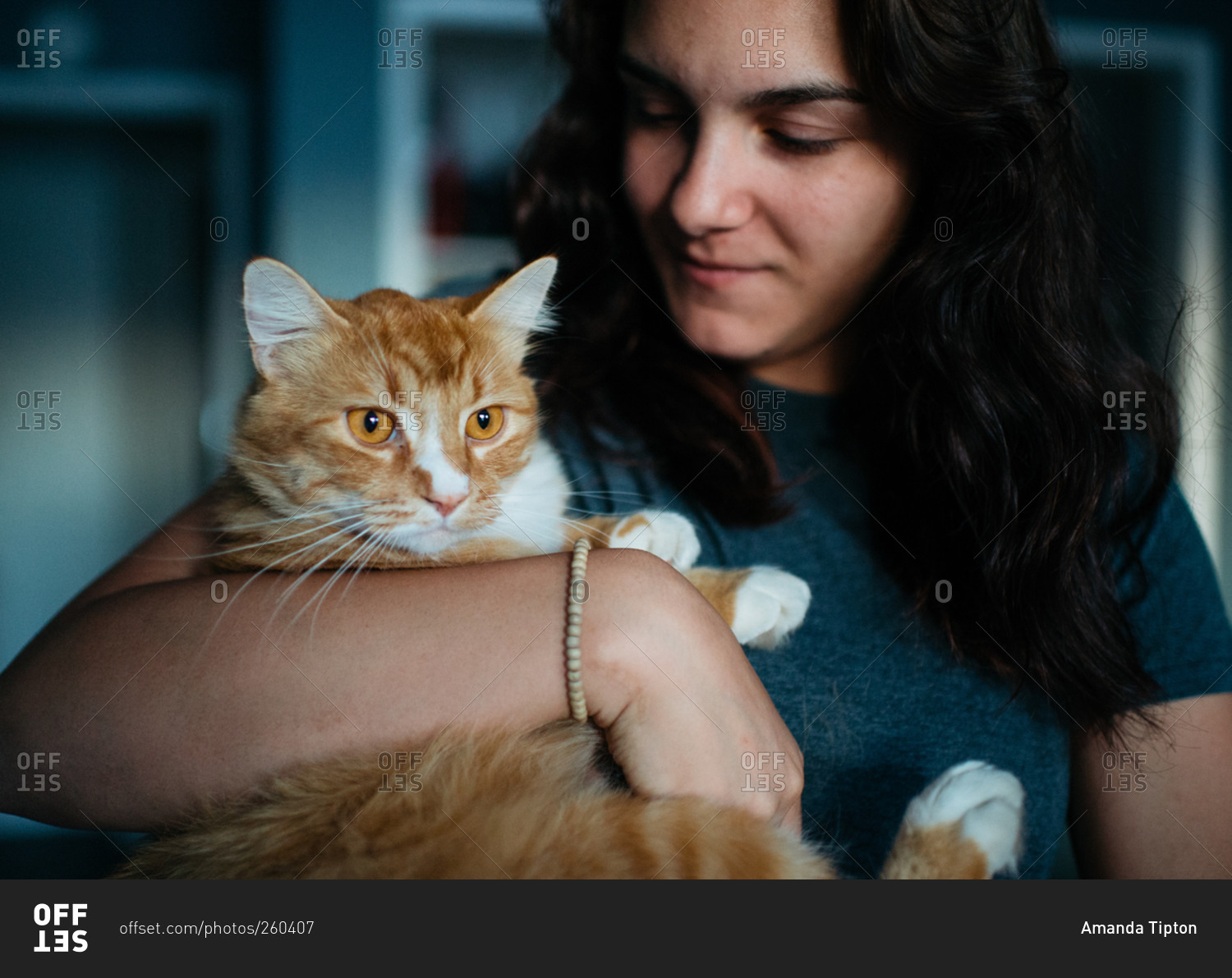 Teenage girl holding her pet orange cat