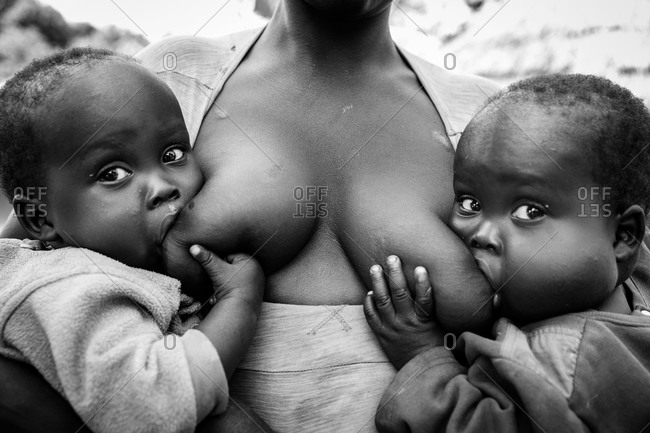 Woman breastfeeding two children