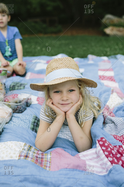 A little girl in a sunhat at a family picnic