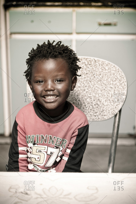 Young boy sitting in a chair smiling