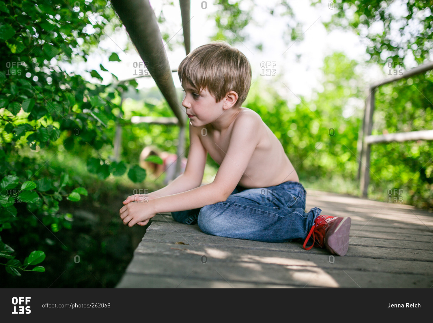 Shirtless Young Boy Looking Over The Edge Of A Footbridge Stock Photo 