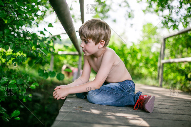 Young Boy Looking Over A Bridge With His Pants Falling Down And The Sign  Hoodlums Over His Head Stock Photo - Alamy