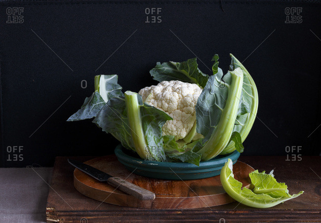 Head of cauliflower in a plate on wooden boards