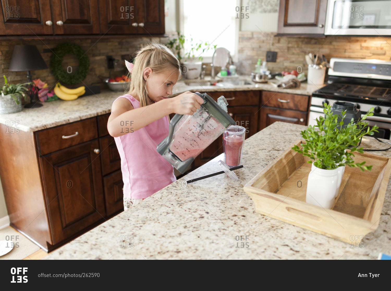 Girl pouring a smoothie into a glass