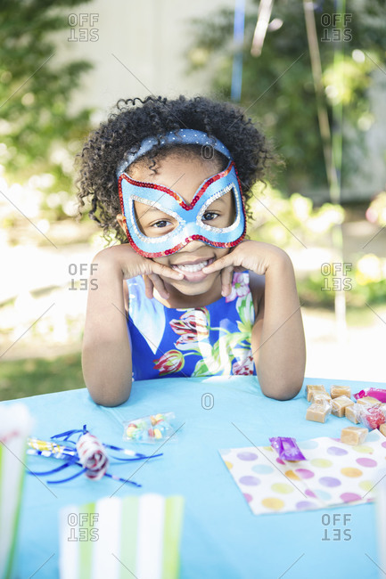 A girl in a mask at a birthday party