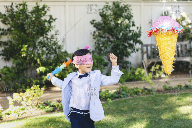 A boy swinging at a pinata at a birthday party