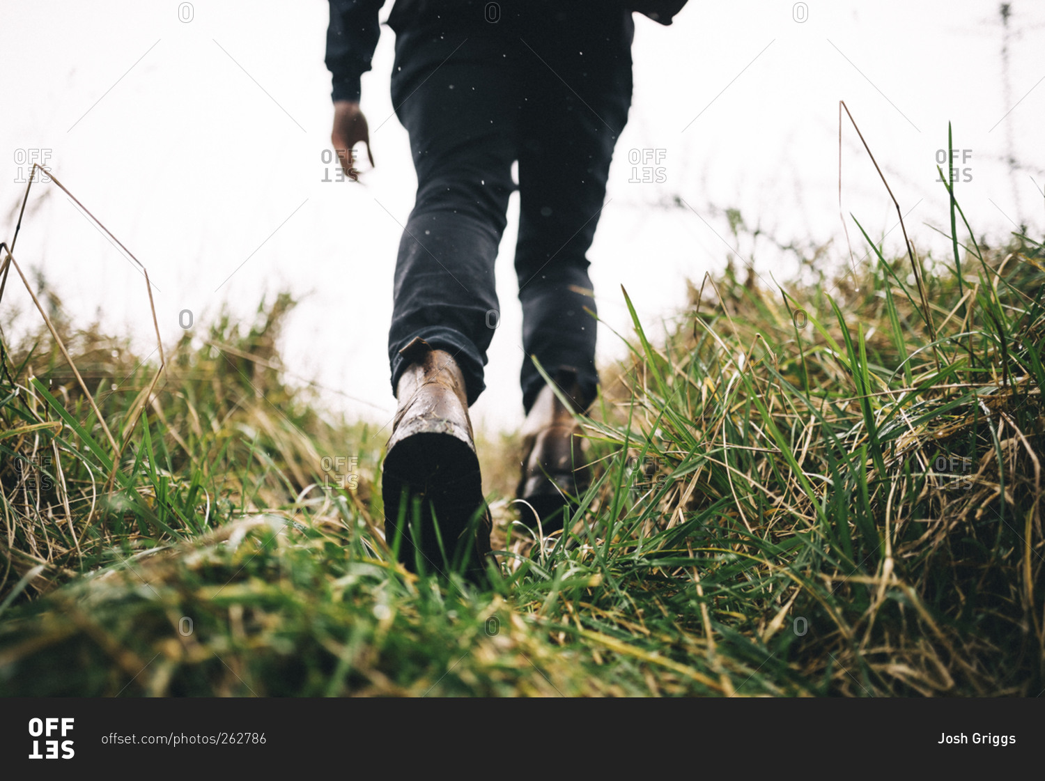 Man hiking through tall grass in leather boots