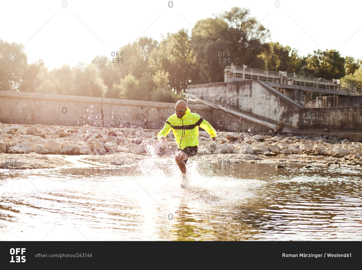 Man in sports wear running through water