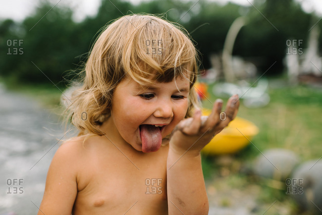 Little girl with mud covered hands being goofy
