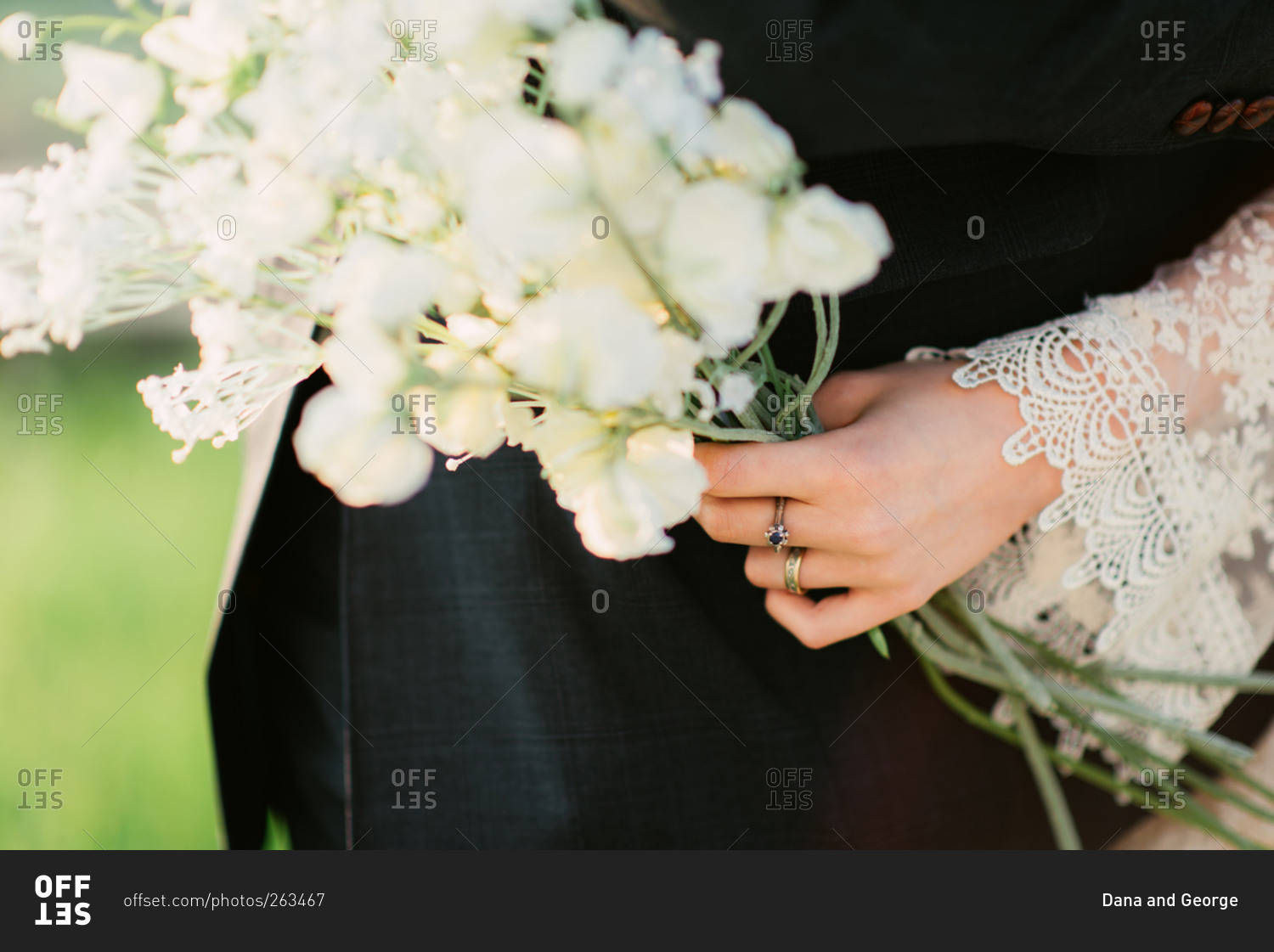 Bride holding bouquet with arms around groom