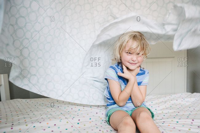 A girl smiles underneath a billowing sheet