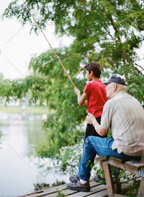 Grandfather teaching his grandson to fish