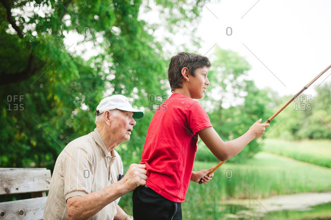 Grandfather helping his grandson learn to fish