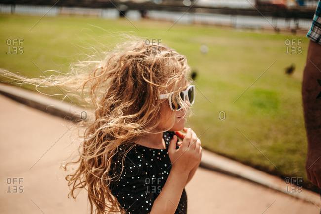 Little girl in sunglasses with windblown hair