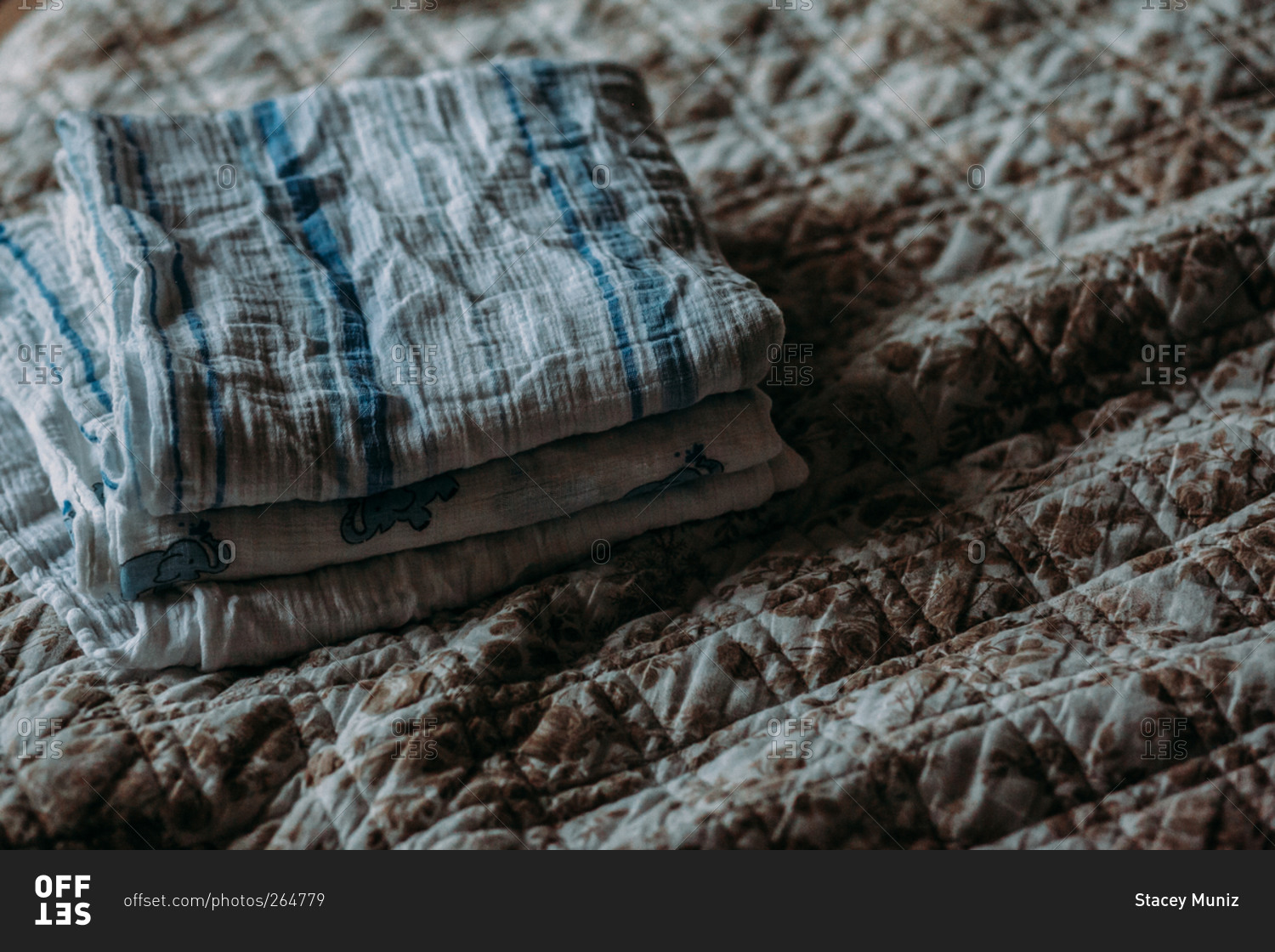 Baby blankets folded and stacked on a bed