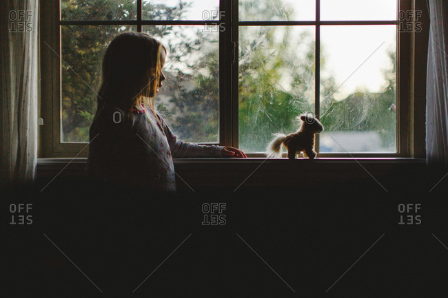Girl in silhouette against house window