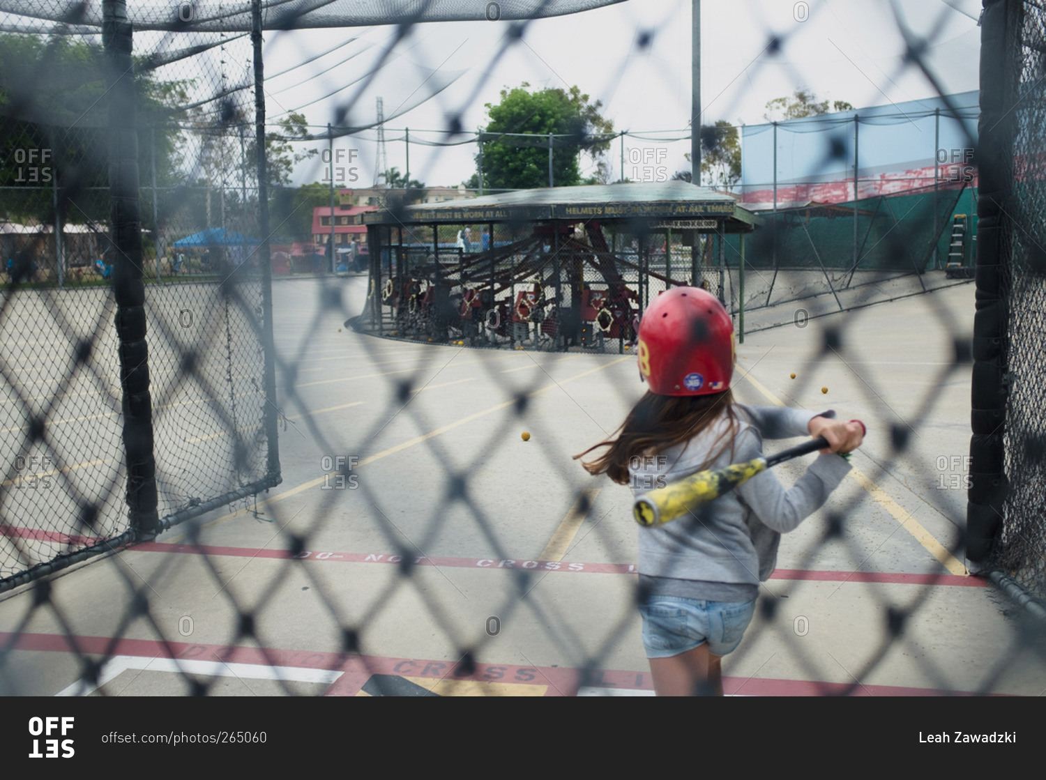 Girl swinging bat in batting cages