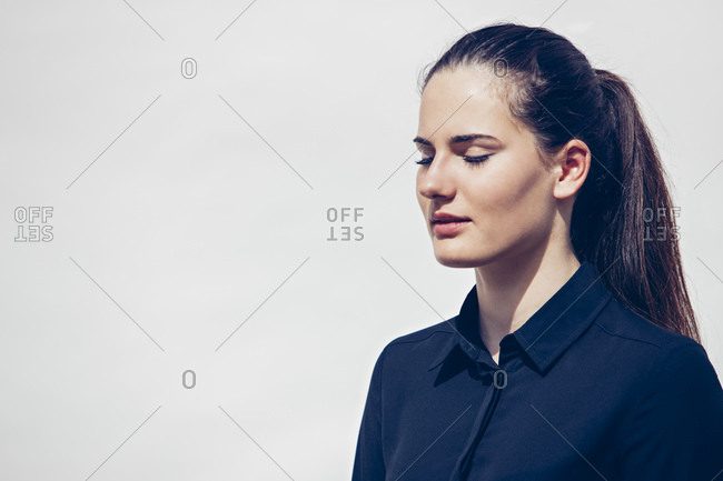 Back view of woman's brown hair tied in a ponytail stock photo - OFFSET