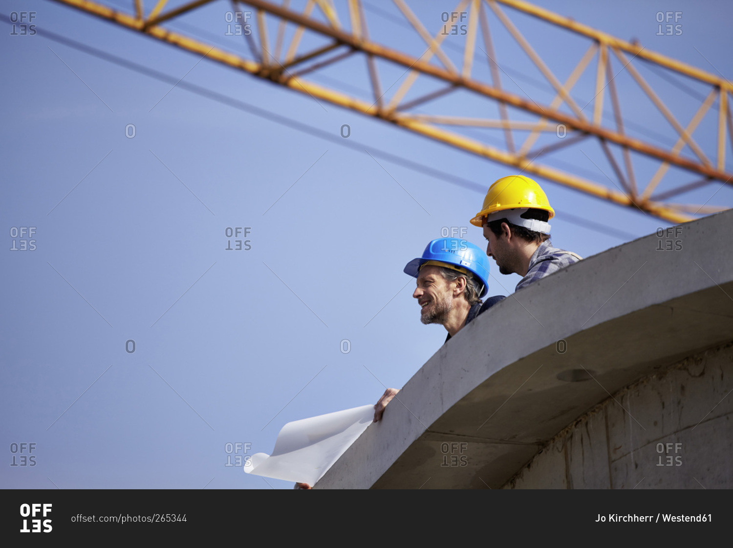 Two men on construction site with construction plan stock photo OFFSET