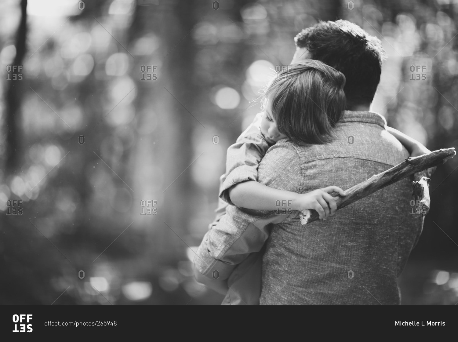 A father gives his son a hug stock photo - OFFSET