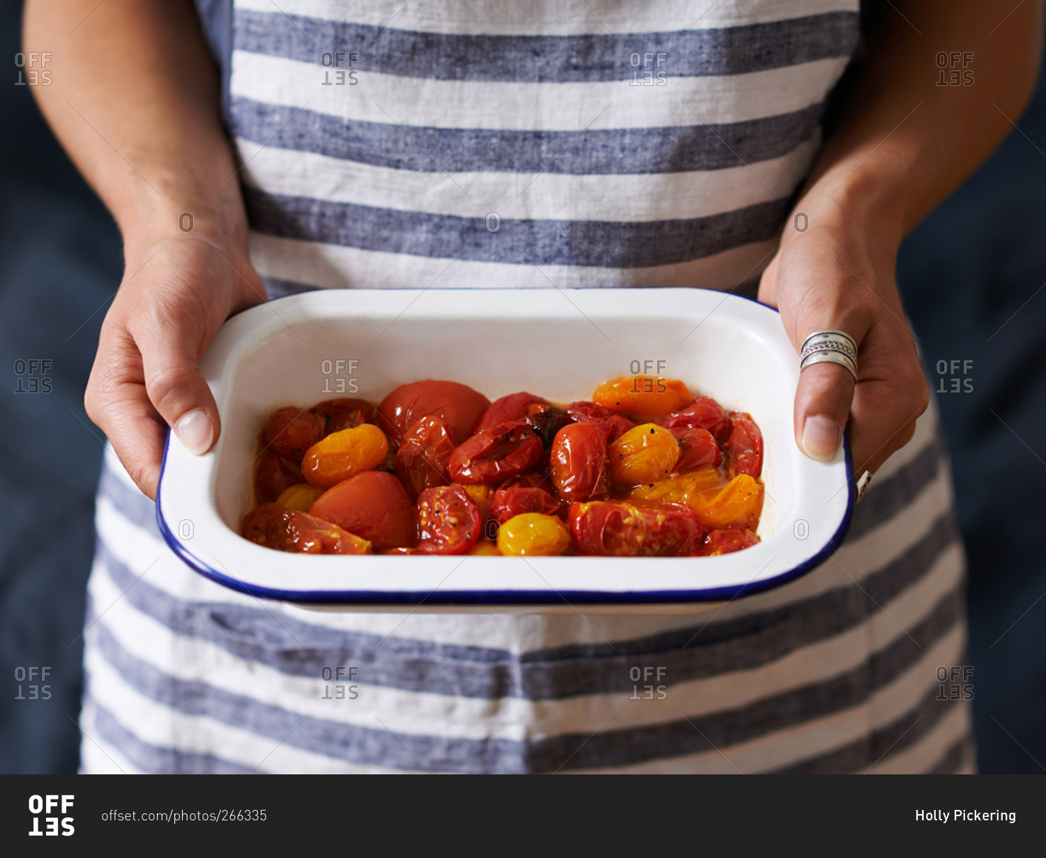 Woman holding enamel dish of roasted tomatoes