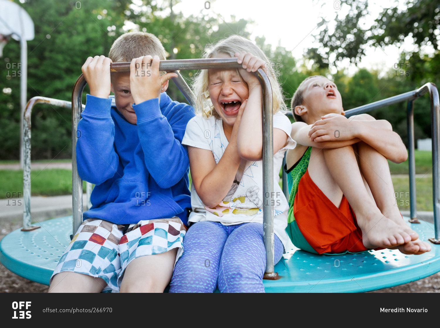 Children pretending to be scared on a merry-go-round