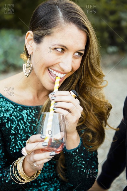 Young woman drinking a cocktail at a party