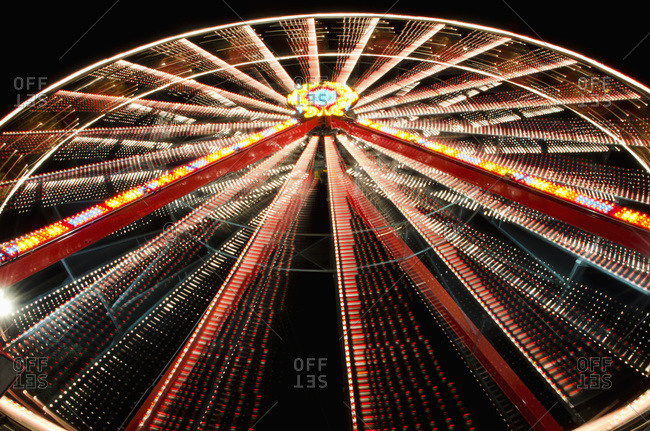 Ferris wheel glowing and spinning at nighttime, Locarno, Ticino, Switzerland